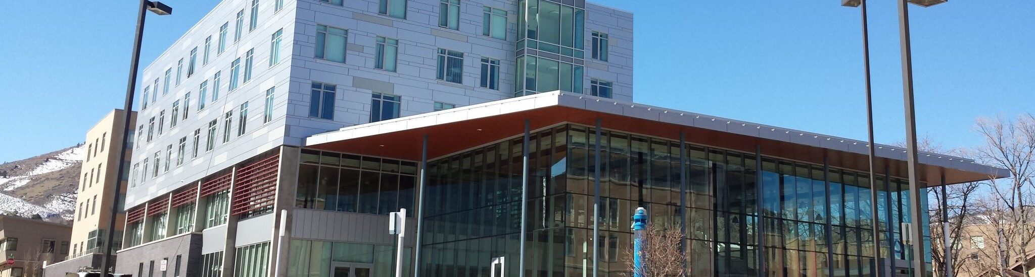 A view of a multistory school building with floor to ceiling windows in front and rows of windows in the background